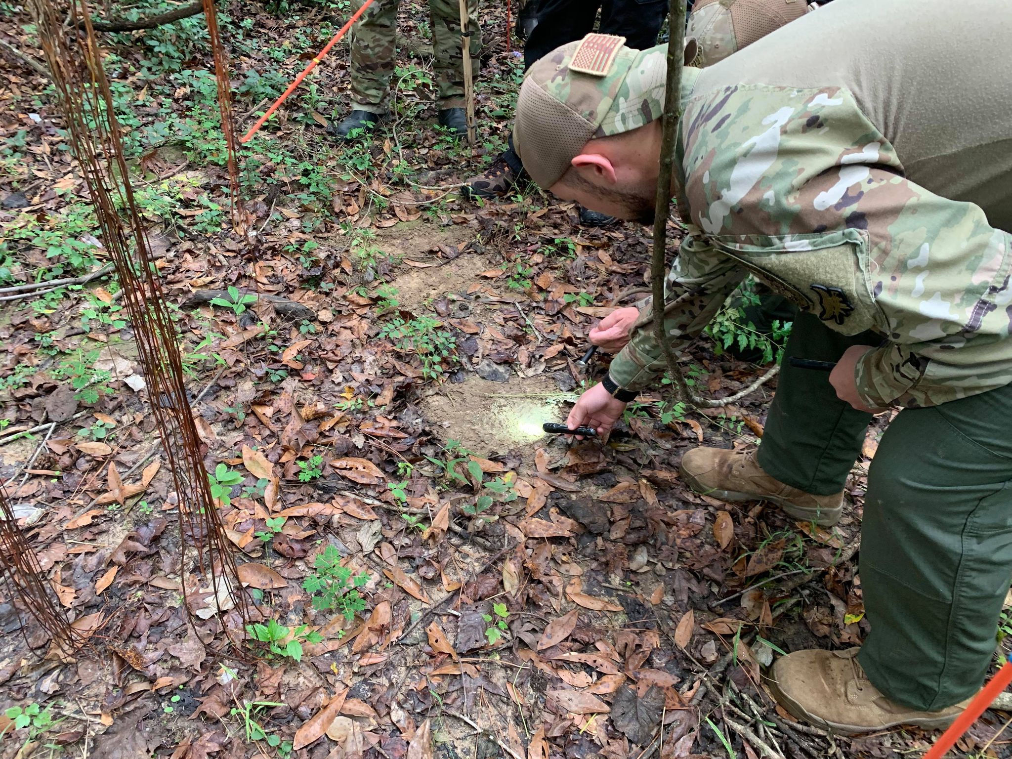 Examining ground sign during field tracking exercise