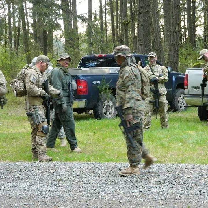 Military and law enforcement personnel staging for tracking exercise